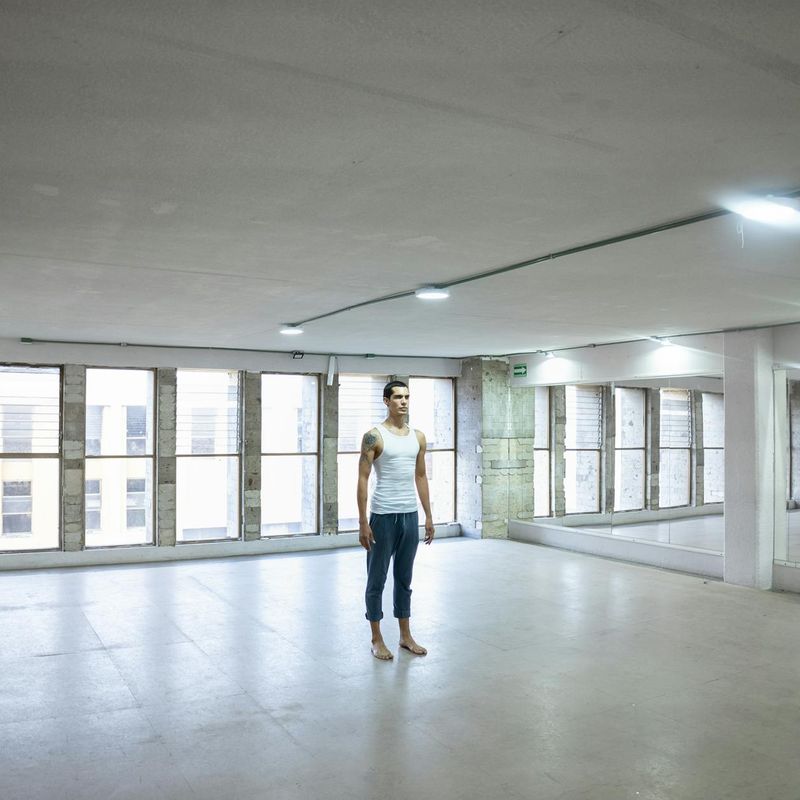 Bright and empty yoga studio with large windows and sunlight