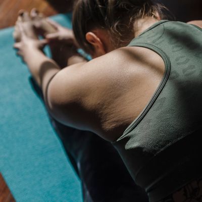 Detailed view of a person stretching legs on a mat